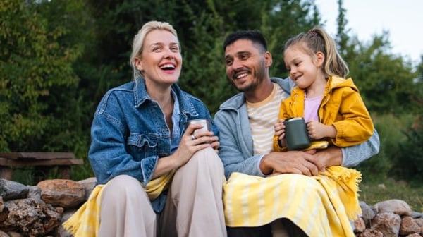 Family sitting together outside, embracing