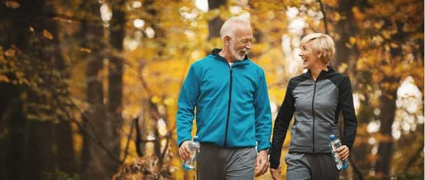 Mature active couple walking in park