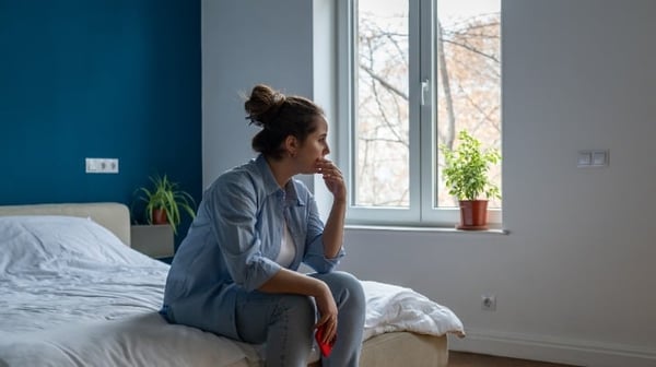 Picture of a woman looking sad staring out the window