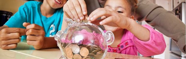 Image showing family putting money in to a savings piggy bank