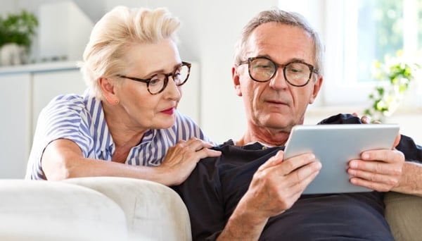 Older couple reading a tablet together