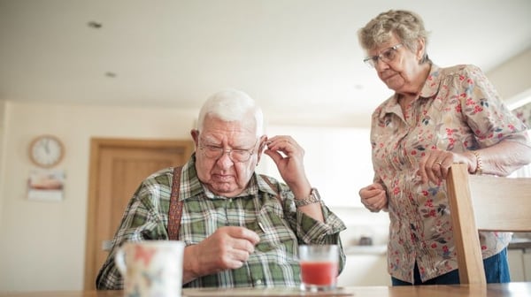 Senior man inserting his hearing aid